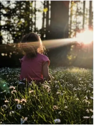 kind staat met gezicht in zonnestraal