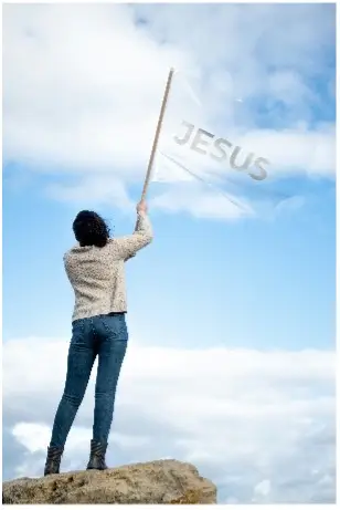vrouw houdt boven op een berg een vlag vast met de tekst: Jezus.
